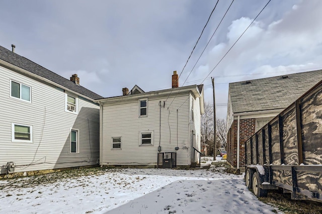 view of snow covered rear of property