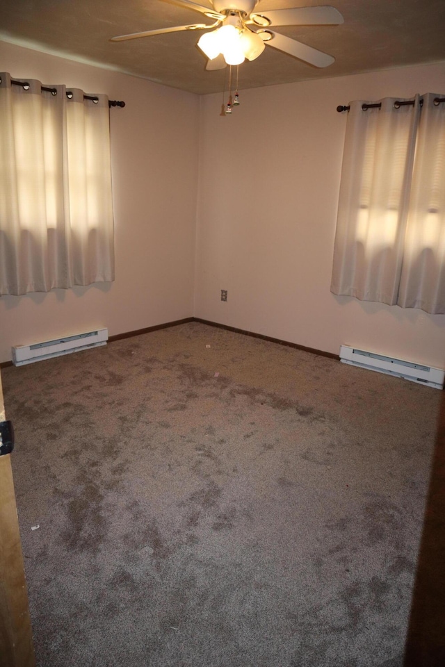 spare room with a baseboard heating unit, ceiling fan, and carpet