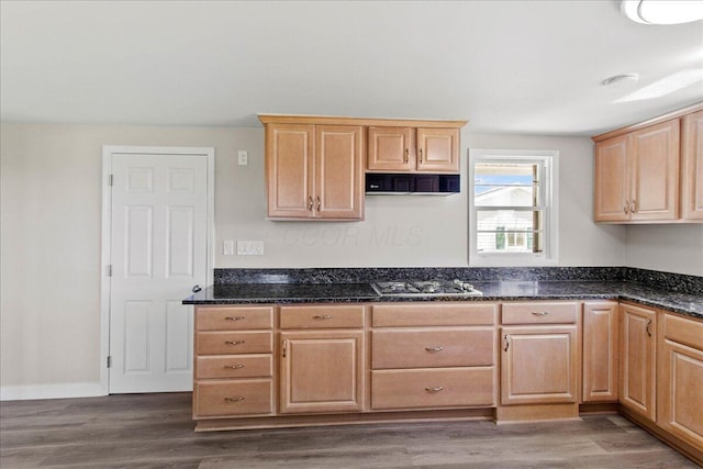 kitchen with stainless steel gas stovetop, light brown cabinetry, extractor fan, and dark wood-type flooring