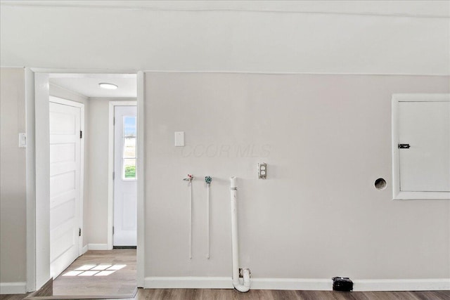 laundry area with baseboards, laundry area, and wood finished floors