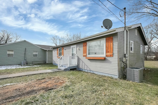 view of front of house with a front yard and central air condition unit