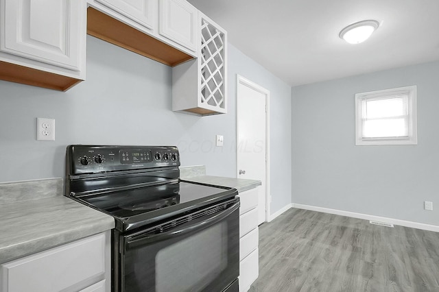 kitchen featuring white cabinetry, black electric range oven, and light wood-type flooring