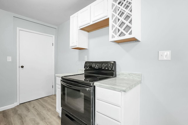 kitchen featuring white cabinets, electric range, and light wood-type flooring