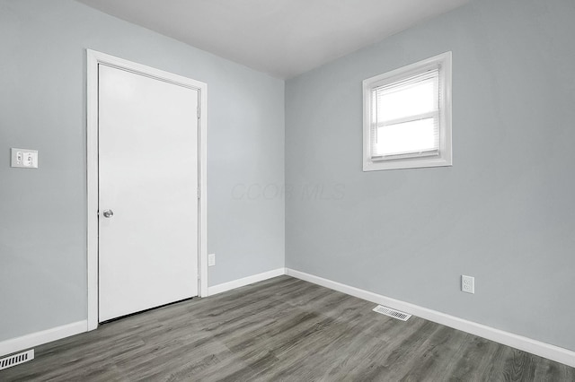 unfurnished room featuring dark hardwood / wood-style flooring