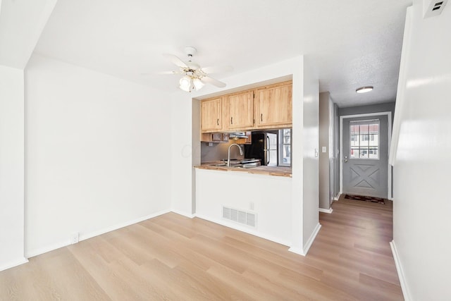 kitchen featuring light brown cabinetry, sink, refrigerator, light hardwood / wood-style flooring, and ceiling fan