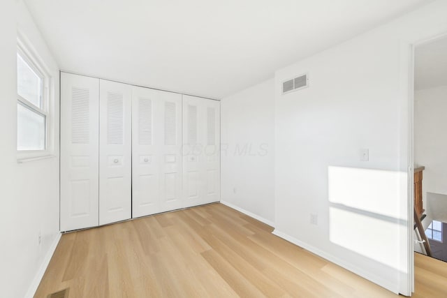 unfurnished bedroom featuring a closet and light hardwood / wood-style flooring