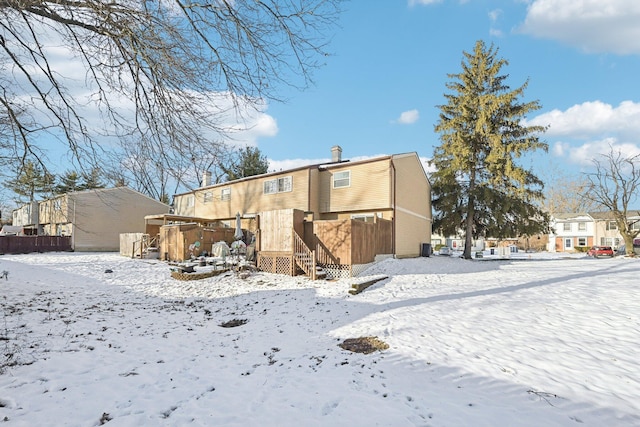 view of snow covered back of property