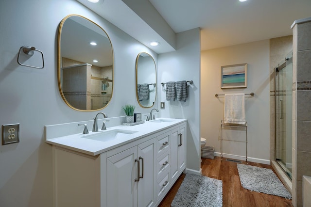 bathroom featuring vanity, toilet, an enclosed shower, and hardwood / wood-style floors