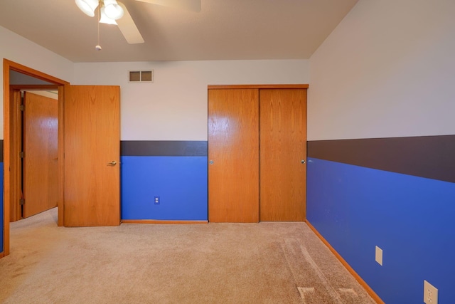 unfurnished bedroom with light carpet, ceiling fan, and a closet