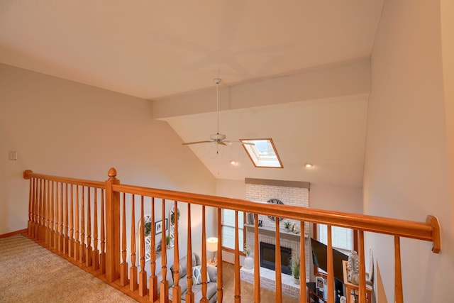 corridor with vaulted ceiling with skylight and carpet