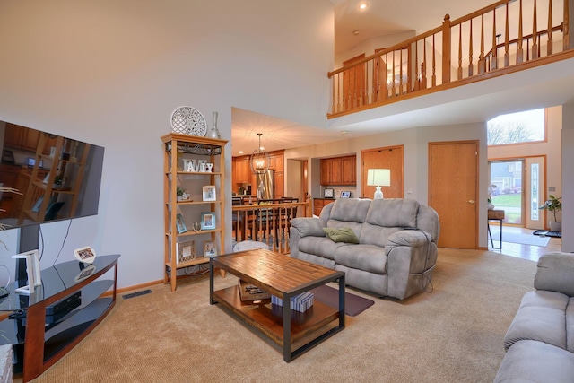 living room with a high ceiling and light carpet