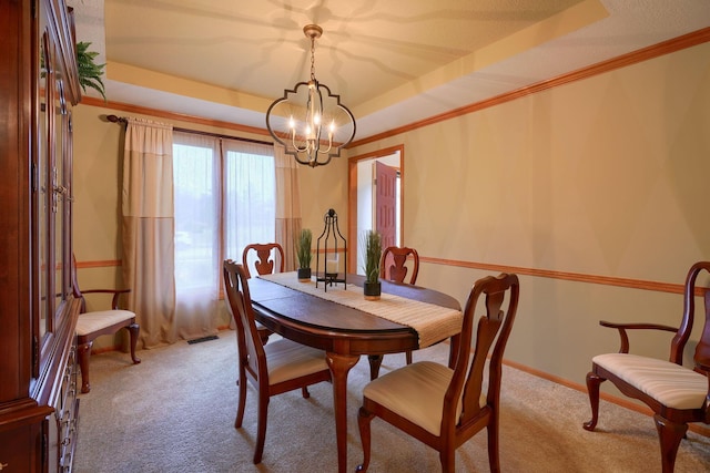 dining space with a raised ceiling, crown molding, and light colored carpet