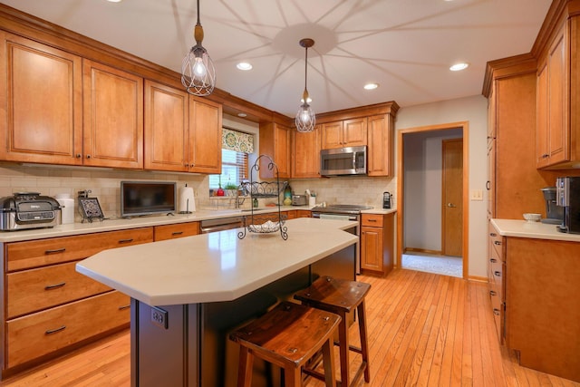 kitchen featuring a center island, light hardwood / wood-style flooring, a kitchen breakfast bar, pendant lighting, and stainless steel appliances