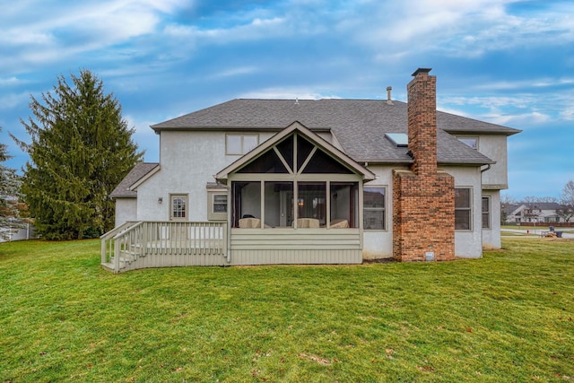 back of property with a yard, a deck, and a sunroom