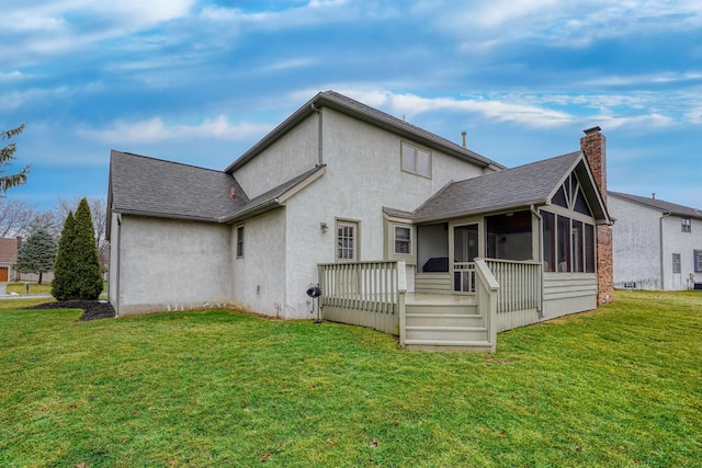 rear view of house with a wooden deck, a yard, and a sunroom