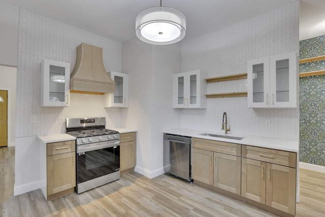 kitchen with sink, light brown cabinets, stainless steel appliances, and premium range hood