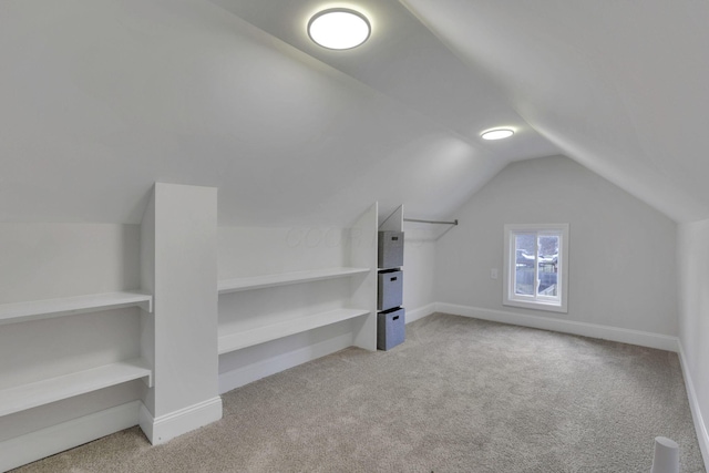 bonus room with lofted ceiling and light carpet