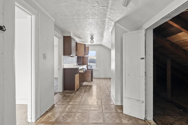 kitchen featuring lofted ceiling, a textured ceiling, and light parquet floors