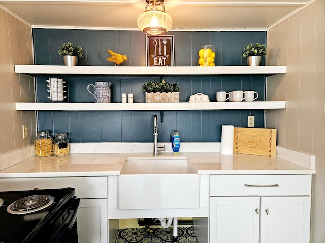 bar with white cabinetry, light stone countertops, sink, and crown molding