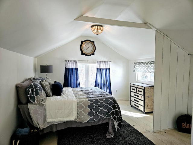 bedroom featuring lofted ceiling, light hardwood / wood-style floors, and multiple windows