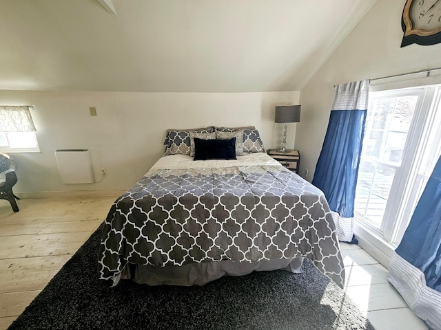 bedroom featuring lofted ceiling and multiple windows