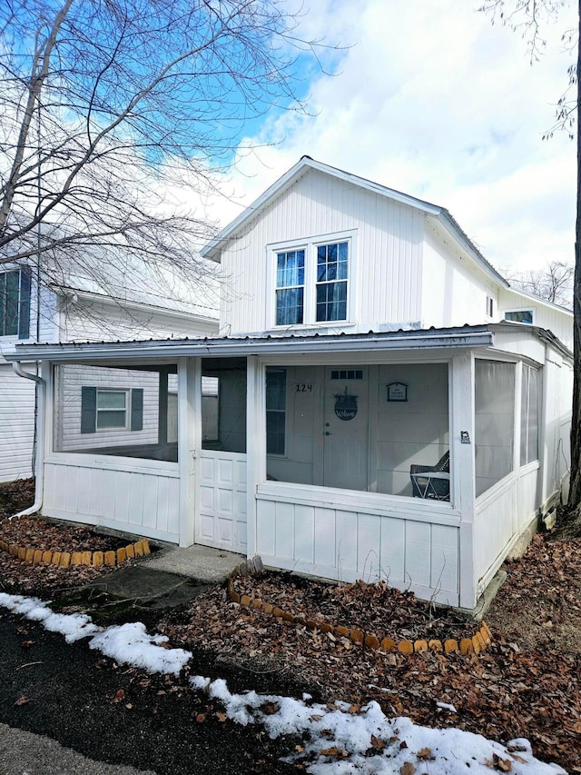 view of snowy exterior featuring a sunroom