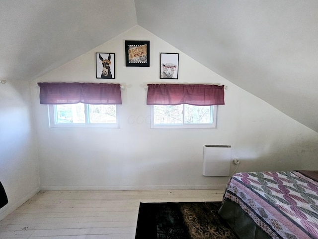 bedroom with vaulted ceiling and light hardwood / wood-style flooring