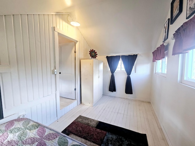 bathroom with vaulted ceiling and wood-type flooring