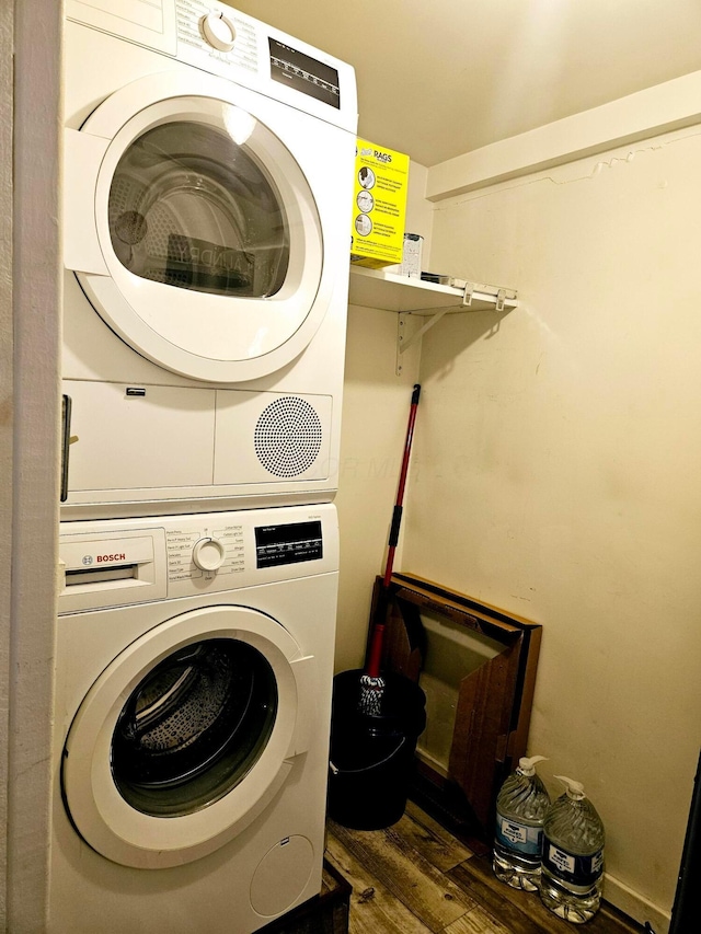 clothes washing area with stacked washer and dryer and dark hardwood / wood-style floors