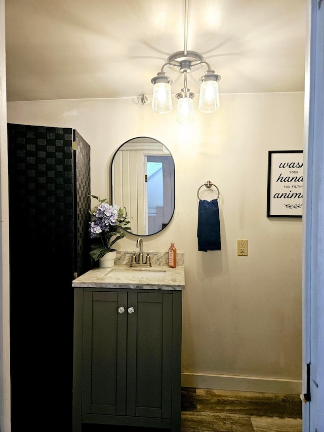 bathroom featuring vanity, hardwood / wood-style floors, and an inviting chandelier