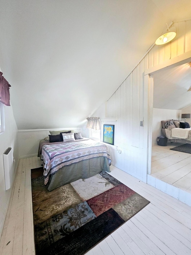 bedroom with hardwood / wood-style flooring and lofted ceiling