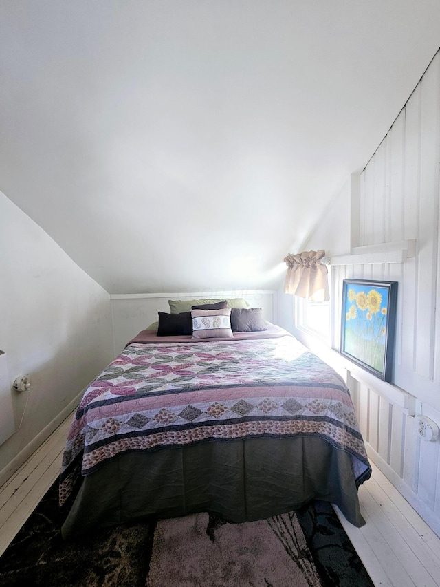 bedroom featuring hardwood / wood-style flooring and vaulted ceiling