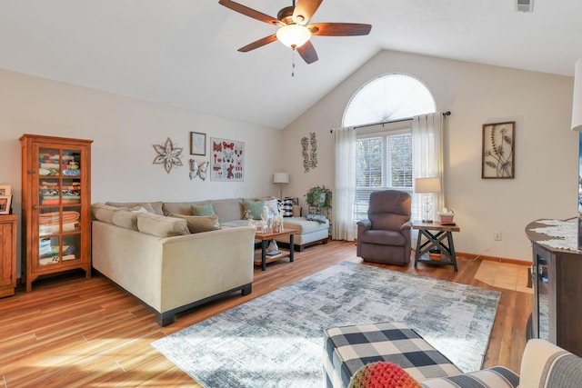 living room with ceiling fan, vaulted ceiling, and light hardwood / wood-style flooring