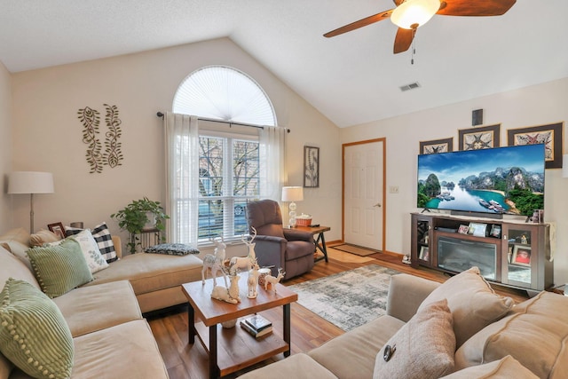 living room featuring vaulted ceiling, ceiling fan, and hardwood / wood-style floors