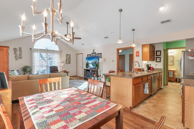 dining room featuring vaulted ceiling, light hardwood / wood-style floors, sink, and a notable chandelier