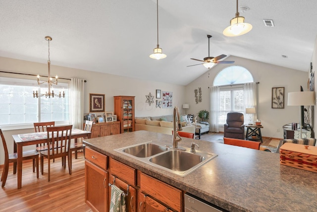 kitchen featuring pendant lighting, sink, light hardwood / wood-style floors, and lofted ceiling