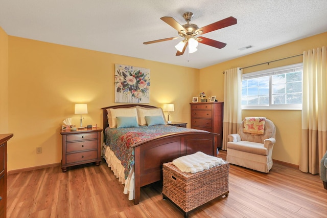 bedroom featuring hardwood / wood-style flooring, a textured ceiling, and ceiling fan