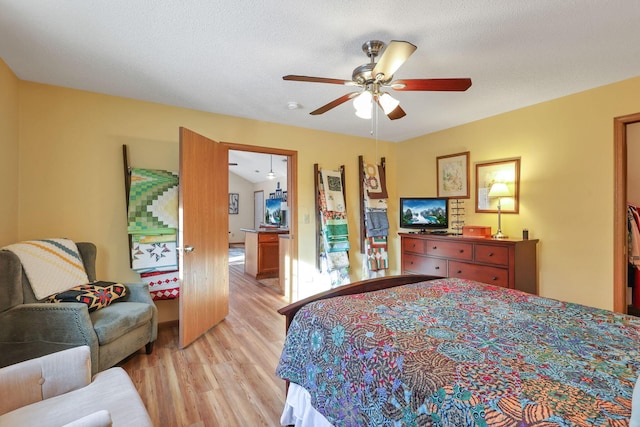 bedroom featuring a textured ceiling, ceiling fan, and light wood-type flooring