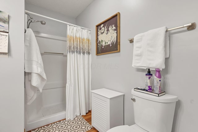 bathroom featuring toilet and a shower with shower curtain