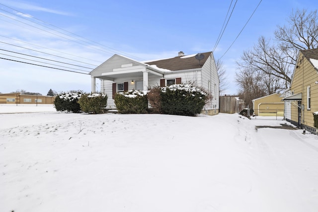 view of snow covered exterior with a garage and an outbuilding