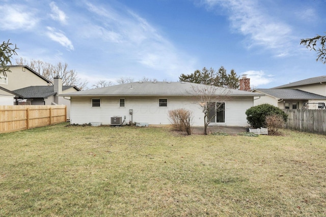 rear view of property featuring a yard and central air condition unit