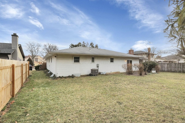 back of property featuring central AC unit and a lawn