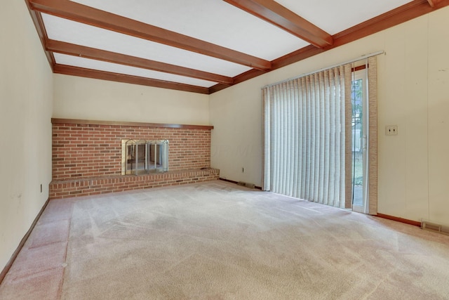 unfurnished living room with beamed ceiling, a brick fireplace, and light carpet