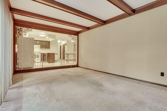 unfurnished living room with light carpet and beamed ceiling