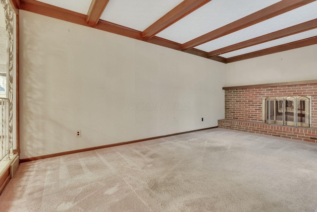 unfurnished living room featuring beamed ceiling, a brick fireplace, and light carpet