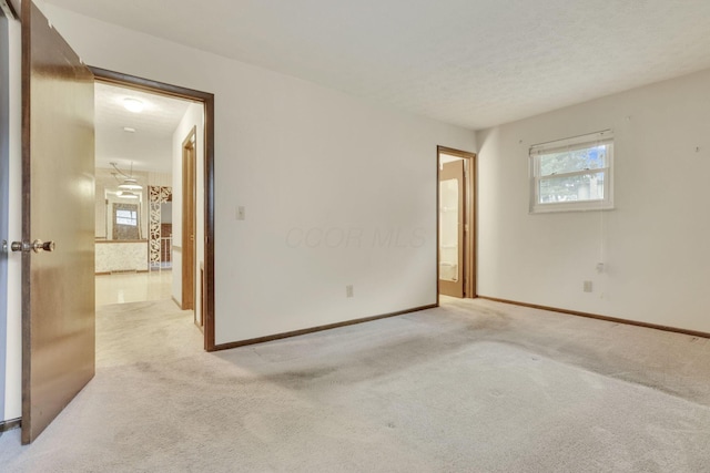 unfurnished room featuring light carpet and a textured ceiling