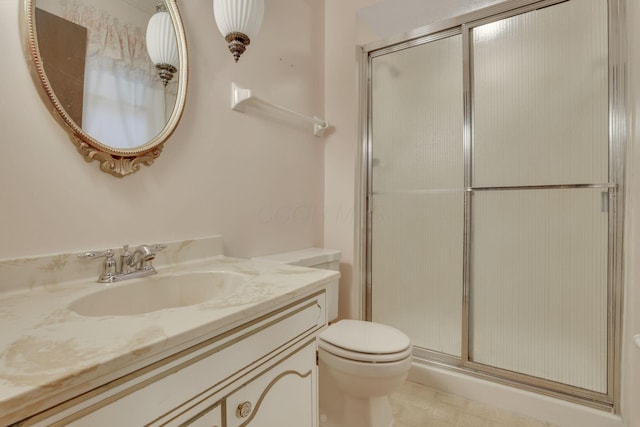 bathroom with vanity, toilet, and a shower with shower door