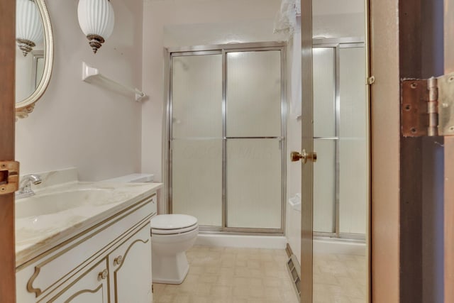 bathroom featuring a shower with door, vanity, and toilet