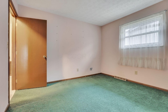 carpeted spare room featuring a textured ceiling