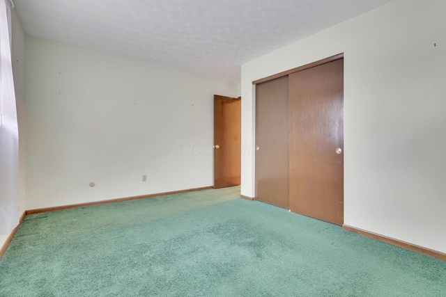 unfurnished bedroom with carpet floors, a textured ceiling, and a closet